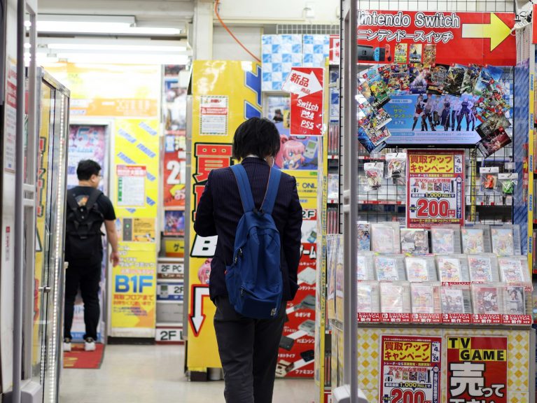 A shopper looks at items in a Japanese electronics store